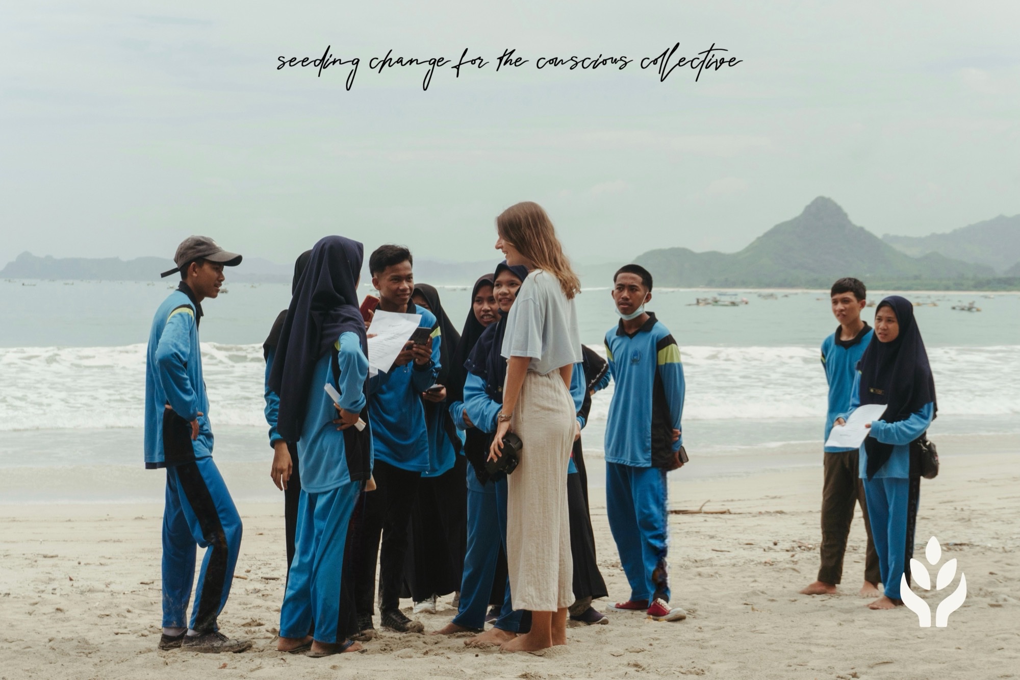 Volunteers and students gathered on a beach, with the 501SEED3 mark and the line seeding change for the conscious collective